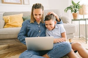 Family looking at a laptop together, creating a pet remembrance site in the UK.